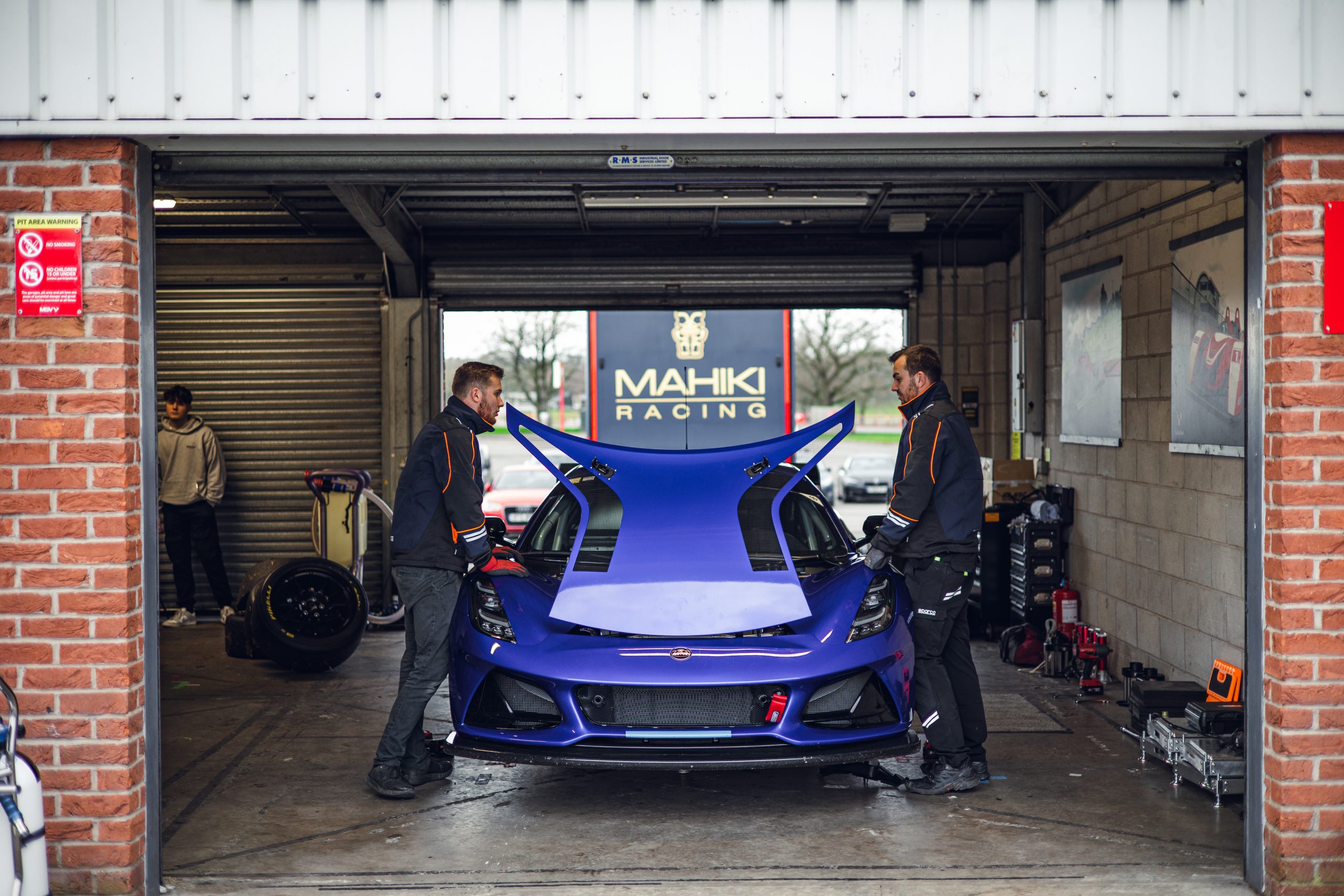 Lotus GT4 with front hood open in garage